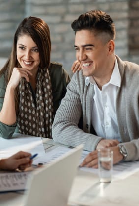Couple heureux recevant des conseils financiers lors d'une rencontre avec un conseiller